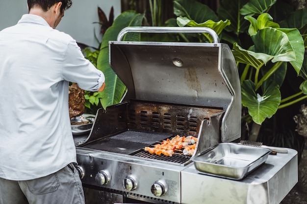man-tattoos-makes-barbecue-grill-meat-outdoors_1321-1043